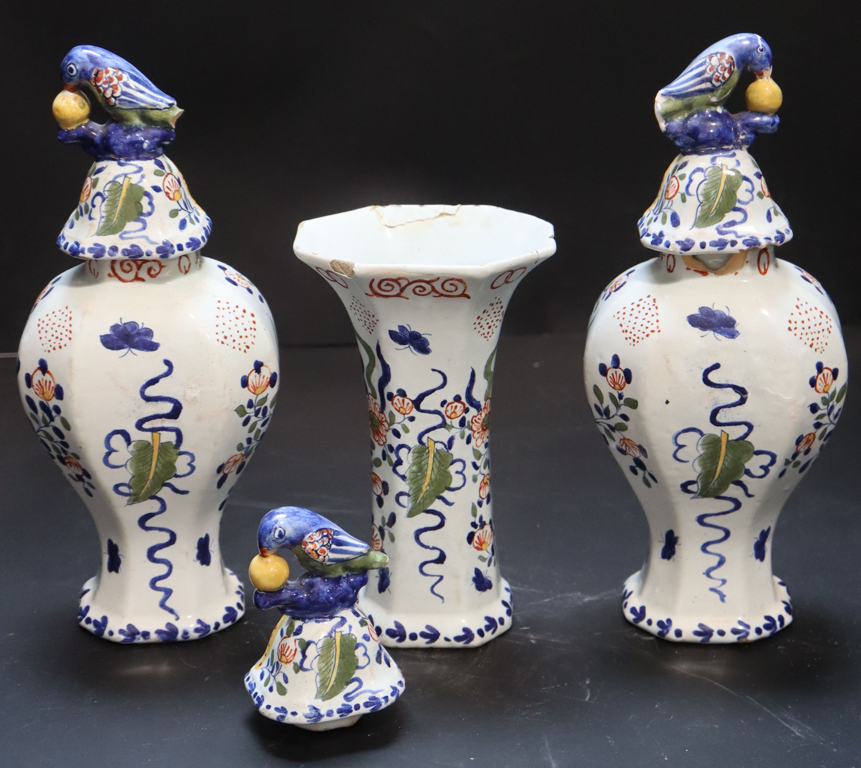 A 19th century Dutch delft polychrome part garniture of three vases, height 27cm and 19cm.